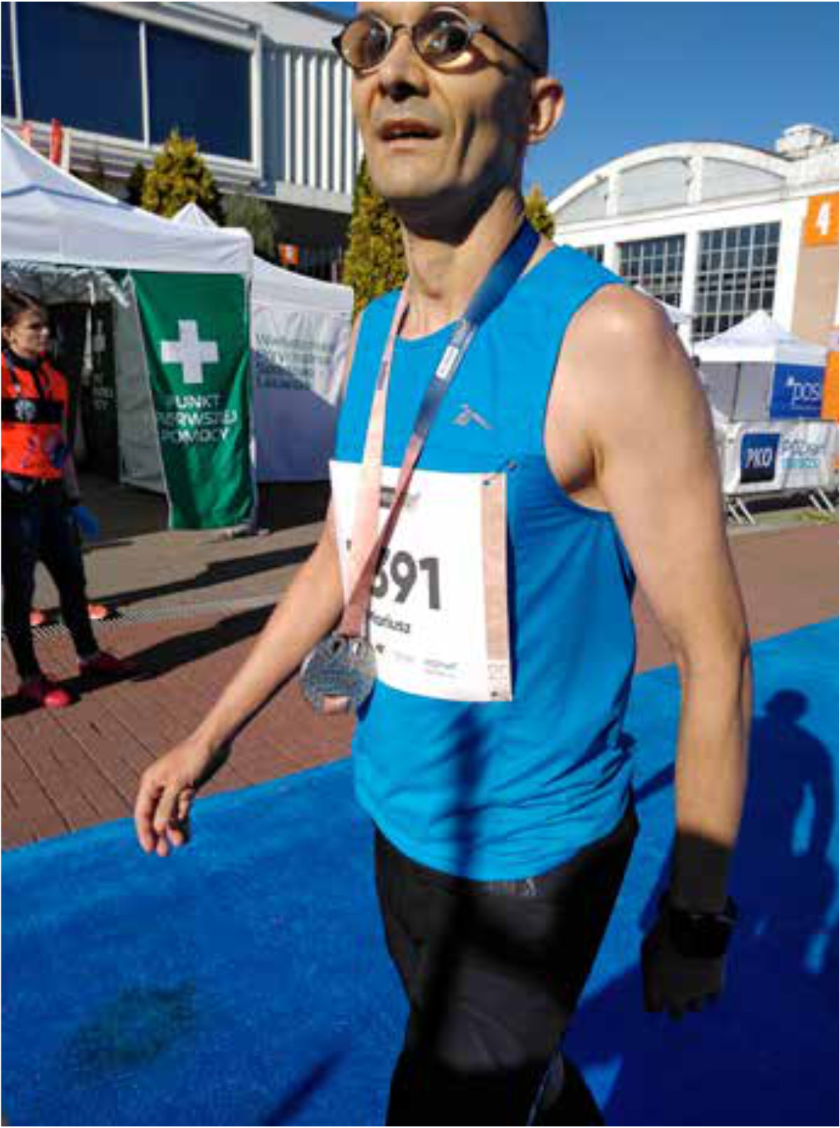 Mężczyzna z numerem startowym, z medalem na szyi