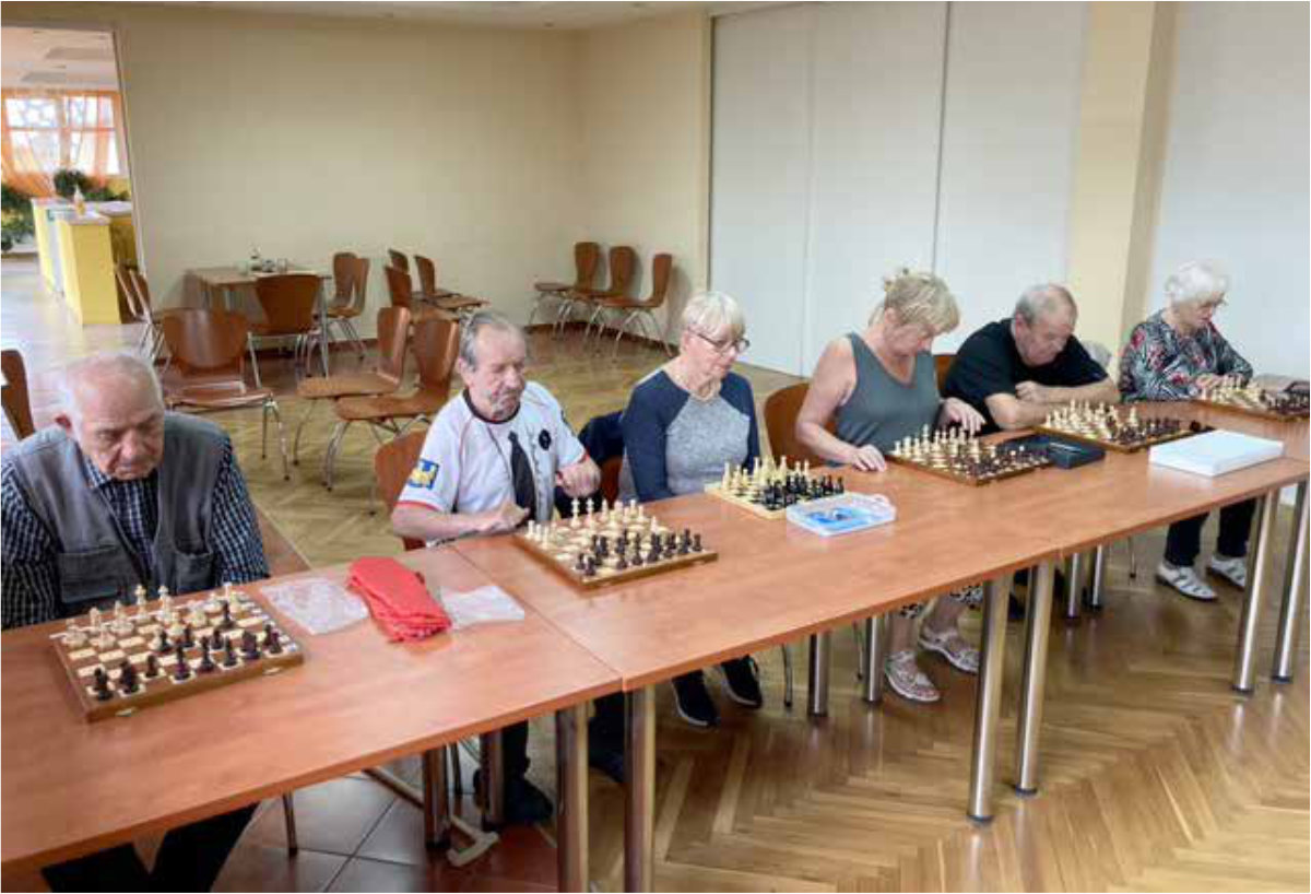 Kursanci ćwiczą grę w szachy przy szachownicach