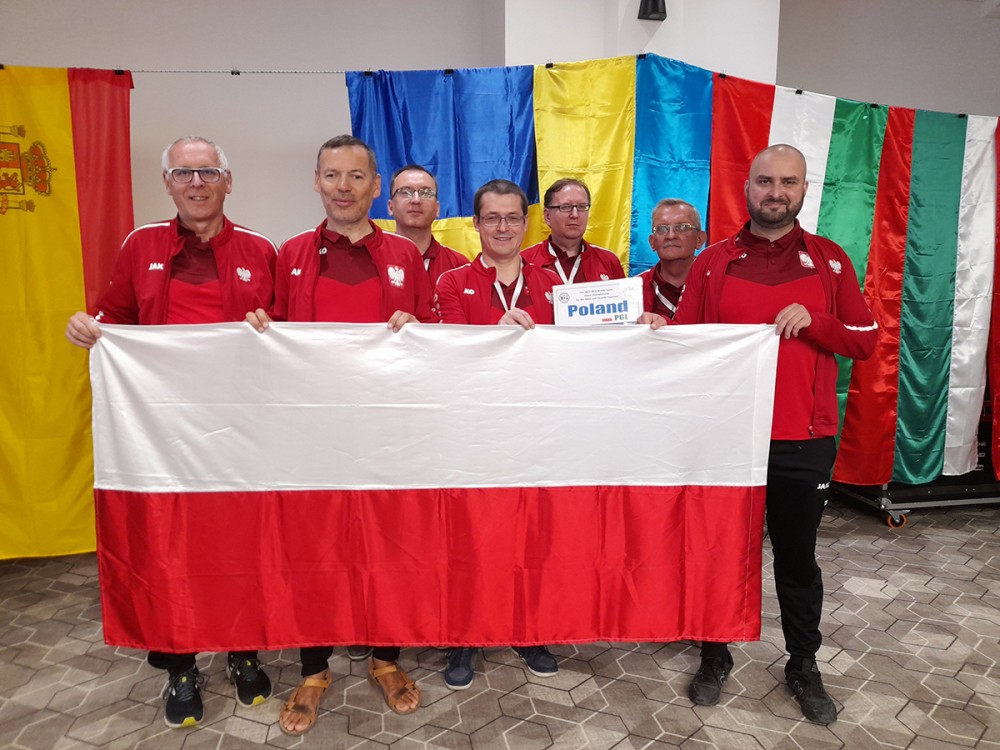 Grupa osób trzyma flagę Polski