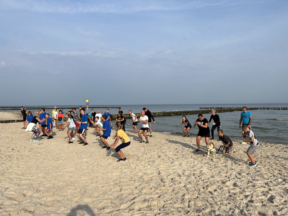 Osoby ćwiczące na plażyi