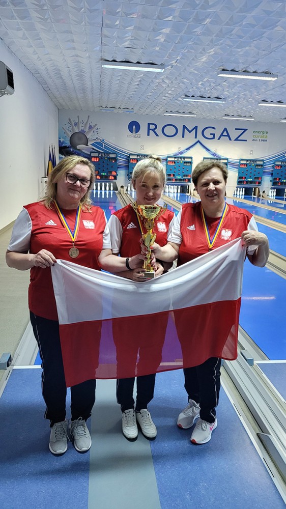 trzy kobiety z pucharami medlami i flagą polski w rękach