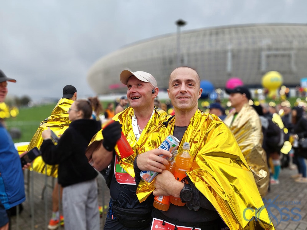grupa os&oacute;b tuż po biegu z foliami termicznymi na ciele