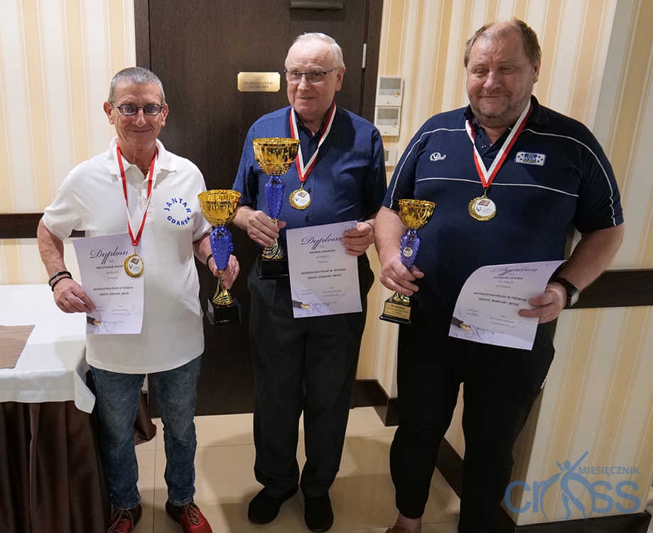 trzech mężczyzn z pucharami i medalami